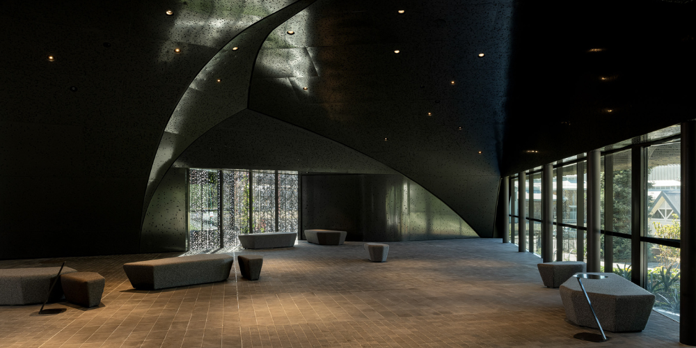 The Eastern Foyer, showing its curved architectural forms, glass walls overlooking City Park and contemporary seating.