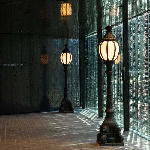 The Eastern Foyer, featuring ornate floor lamps beside the glass wall overlooking City Park.