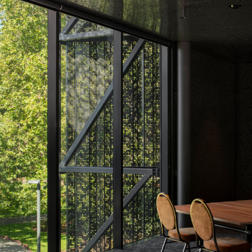 The Tamar Valley Room, with floor-to-ceiling windows overlooking City Park and a table and chairs beside the glass wall.